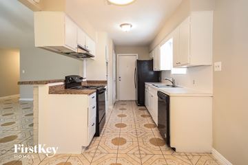 Spring house for rent - A kitchen with a tile floor and a refrigerator in the background.