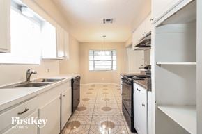 Spring house for rent - A kitchen with a tile floor and white cabinets.