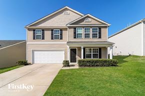 Whitsett house for rent - a tan house with a white garage door
