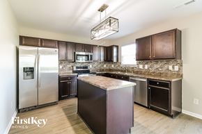 Whitsett house for rent - a modern kitchen with stainless steel appliances and granite counter tops