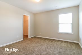 Whitsett house for rent - a bedroom with a carpeted floor and a door to a closet