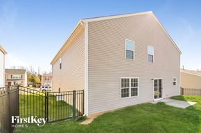Whitsett house for rent - the outside of a house with a fenced in yard and grass