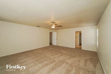 Live Oak house for rent - a spacious living room with carpet and a ceiling fan