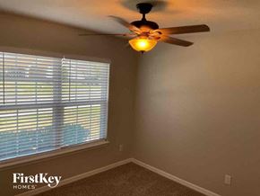 Deland house for rent - a bedroom with a ceiling fan and a window