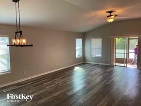 Deland house for rent - an empty living room with wood floors and a ceiling fan