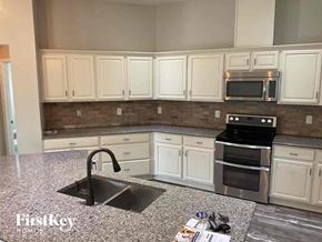 Deland house for rent - a kitchen with white cabinets and a sink