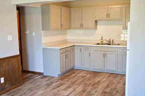 Jefferson City apartment for rent - an empty kitchen with white cabinets and a sink