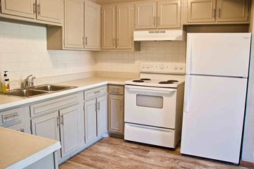 Jefferson City apartment for rent - A white refrigerator is in a kitchen with white appliances.