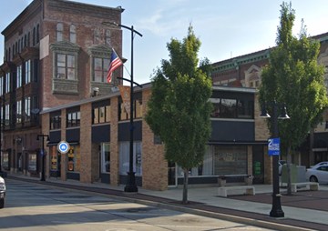 Decatur apartment for rent - A street view of a city with a building on the left and a tree in the middle.