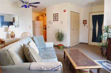 Narragansett apartment for rent - A living room with a grey couch and a wooden coffee table.