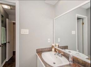 Baton Rouge apartment for rent - A bathroom with a sink, mirror, and light switches.