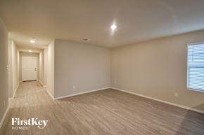 Converse house for rent - a spacious living room with wood flooring and a white door