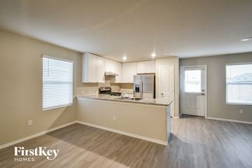 Converse house for rent - a kitchen with white cabinets and a counter top
