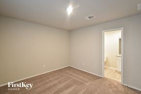 Converse house for rent - a bedroom with a carpeted floor and a door to a bathroom
