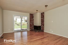 Saint Louis house for rent - A room with wooden floors and a brick fireplace.