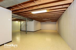 Saint Louis house for rent - A spacious room with wooden ceiling and white walls, with a FirstKey HOMES logo on the bottom left.