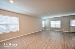San Antonio house for rent - the living room of an empty house with wood flooring and windows