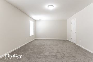 Camby house for rent - the spacious living room with carpet and a door to the bedroom