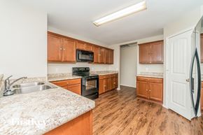 Nevada house for rent - a kitchen with wooden cabinets and granite counter tops and a stainless steel sink