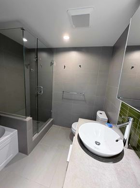 Vancouver apartment for rent - A modern bathroom with a white sink and grey tiles.