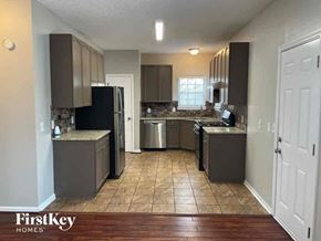 Mableton house for rent - an empty kitchen with stainless steel appliances and wooden floors