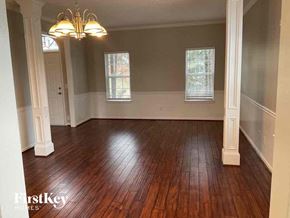 Mableton house for rent - an empty living room with wood floors and a chandelier