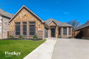 Mansfield house for rent - a large brick house with a driveway and a garage door