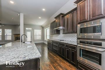 Mansfield house for rent - a kitchen with wood cabinets and marble counter tops and stainless steel appliances