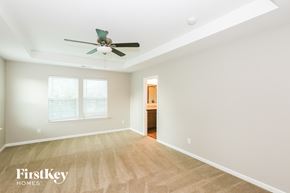 Denver house for rent - A spacious room with a fan and a door in the background.