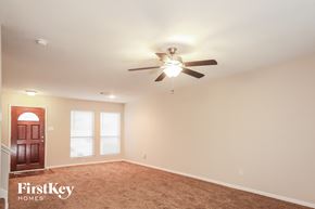 Humble house for rent - an empty room with a ceiling fan and a door
