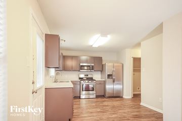 Humble house for rent - a kitchen with stainless steel appliances and a wooden floor