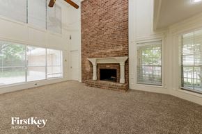 Spring house for rent - a living room with a brick fireplace and a carpeted floor