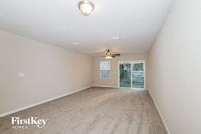 Jacksonville house for rent - an empty living room with a ceiling fan and a window