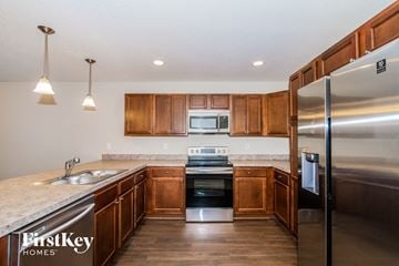 Jacksonville house for rent - a kitchen with wooden cabinets and stainless steel appliances