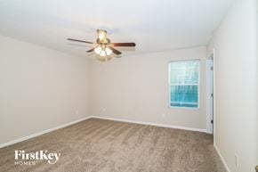 Jacksonville house for rent - a bedroom with carpet and a ceiling fan