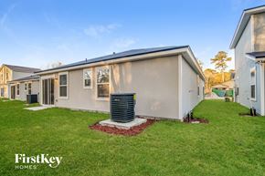 Jacksonville house for rent - a beige house with a heater in the grass