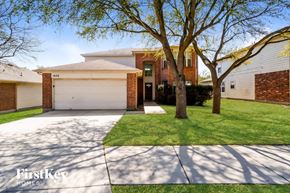 Schertz house for rent - A house with a garage and a tree in front of it.