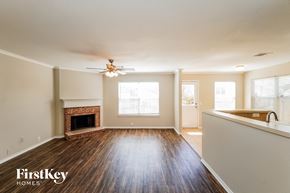 Schertz house for rent - A spacious living room with wood flooring and a fireplace.