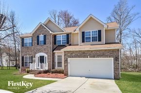 Greensboro house for rent - a home with a white garage door and a brick house