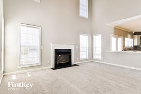 Greensboro house for rent - an empty living room with a fireplace and windows
