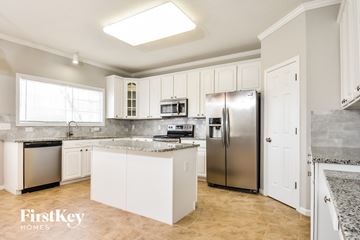 Greensboro house for rent - a kitchen with white cabinets and stainless steel appliances