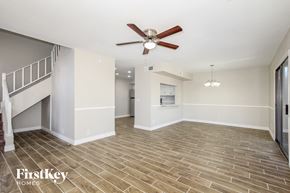 Glendale house for rent - an empty living room with a ceiling fan and a staircase