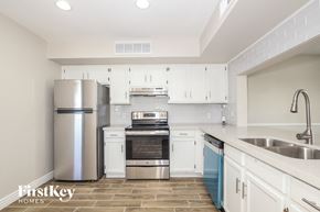 Glendale house for rent - a kitchen with white cabinets and stainless steel appliances