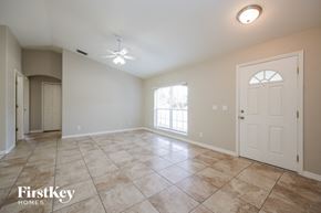 North Pt house for rent - an empty living room with a white door and tile flooring