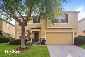 Lakeland house for rent - a large yellow house with a tree in front of it