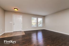 Lakeland house for rent - an empty living room with wood floors and a white door