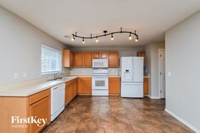 Lakeland house for rent - an empty kitchen with white appliances and wooden cabinets