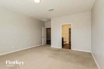 Buckeye house for rent - a spacious living room with carpet and a door to the bathroom