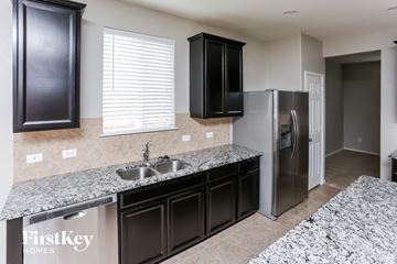 Forney house for rent - a kitchen with granite counter tops and a stainless steel refrigerator