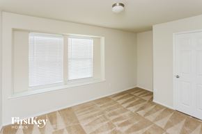 Forney house for rent - a bedroom with a window and a door and a carpeted floor